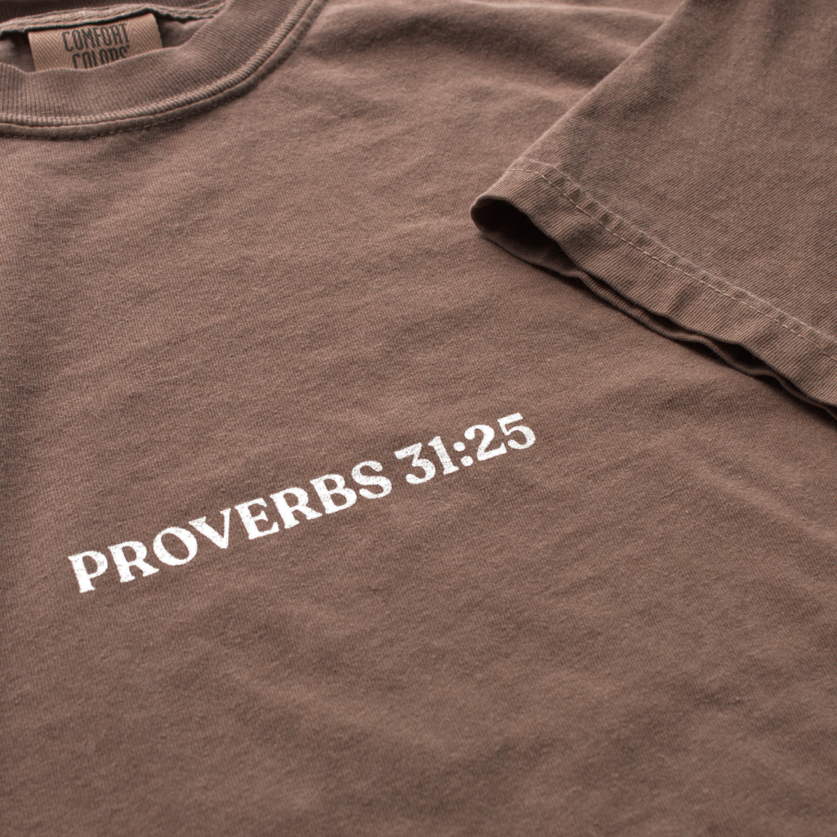 Close up of Brown t-shirt with 'Proverbs 31:25' printed on it