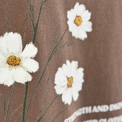 Close up of the White flowers with yellow centers on a brown tshirt. 
