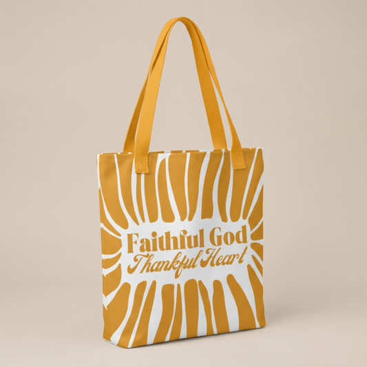 Yellow tote bag with 'Faithful God Thankful Heart' text and a fun stripe design displayed on a beige background