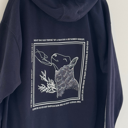 Closer look at Navy blue hoodie with white graphic line drawing of sheep being found and comforted by the hand of Jesus 