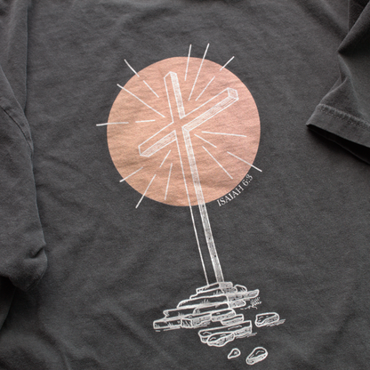 Close up of Gray t-shirt with a white graphic design of a cross and peach colored circle with text 'Isaiah 6:3' in the corner