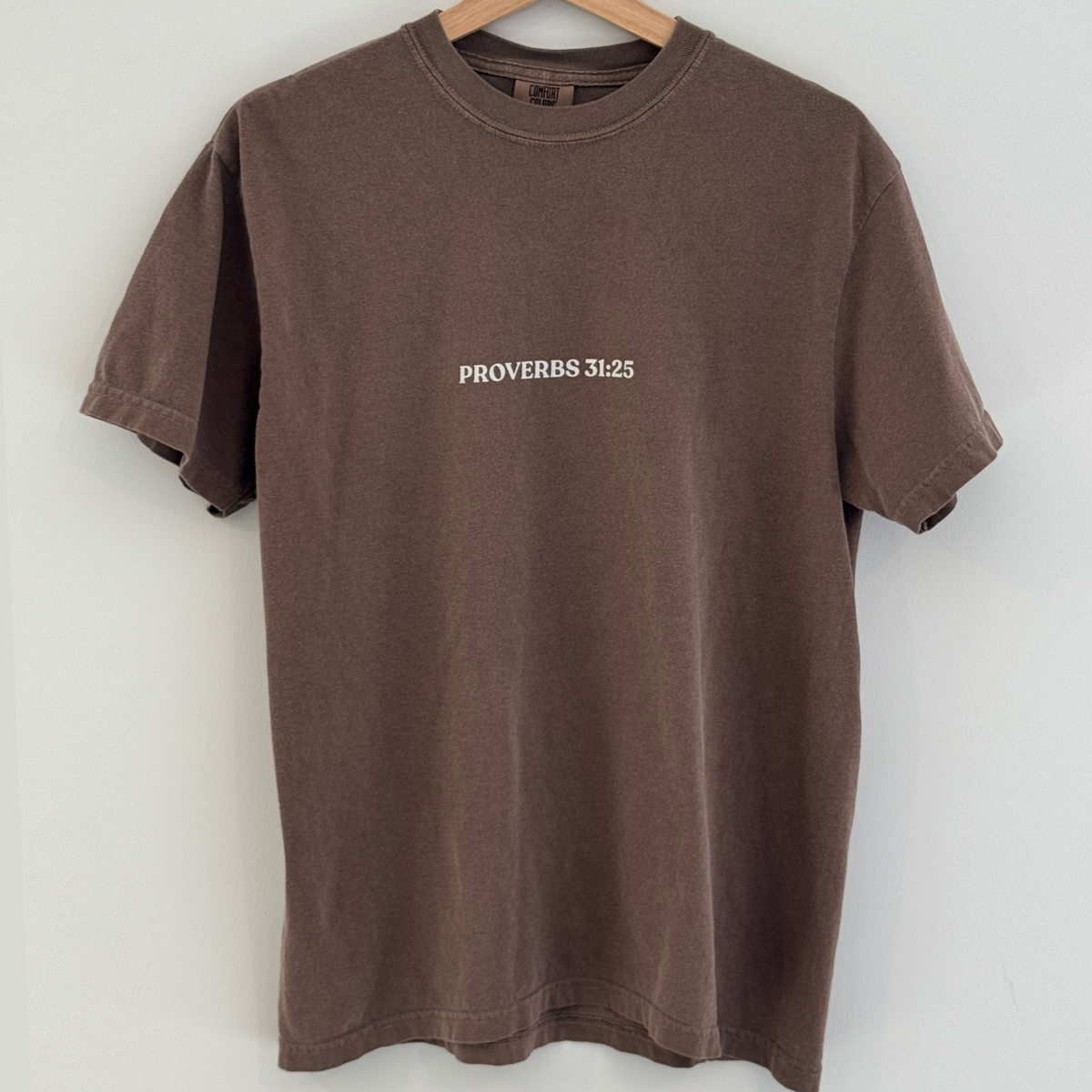 Brown t-shirt with 'Proverbs 31:25' text on a white background