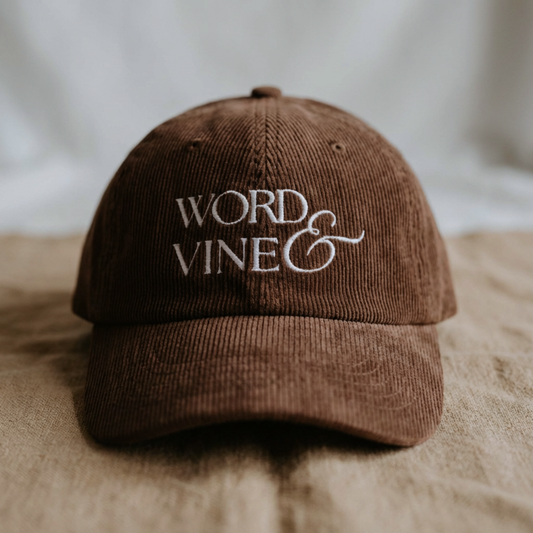 Brown Corduroy ball cap hat with 'WORD & VINE' logo embroidered in white thread on the front. 